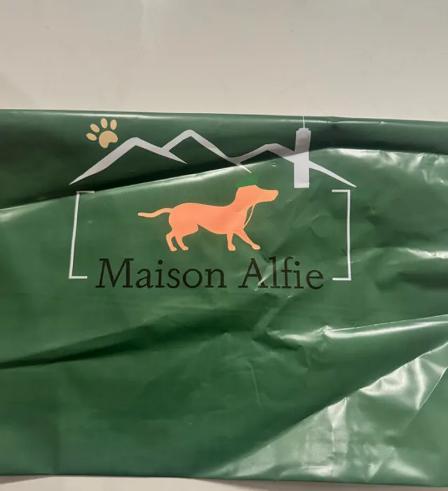 This is a custom poly mailer with the printed text 'Maison Alfie' and images of a dog, a paw print, and mountain-like shapes, likely for a pet-related brand.